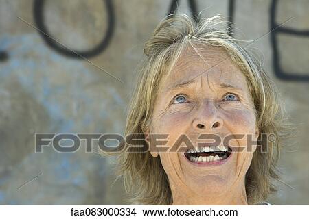 Picture - Senior woman looking up with fearful expression on face. Fotosearch