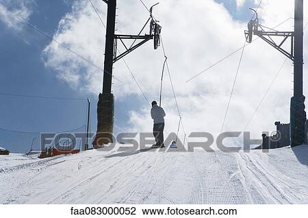 Skier riding ski lift, rear view View Large Photo Image Stock Image - Skier riding ski lift, rear view. Fotosearch