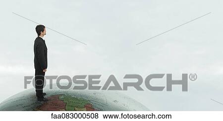 Successful businessman stands on top of the world View Large Photo Image Stock Photo - Successful businessman stands on top of the world. Fotosearch
