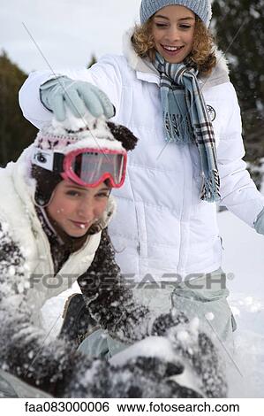Stock Photograph - Teenage girls playing in snow. Fotosearch
