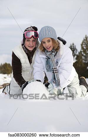 Teenage girls rolling snowball together, portrait View Large Photo Image Stock Image - Teenage girls rolling snowball together, portrait. Fotosearch