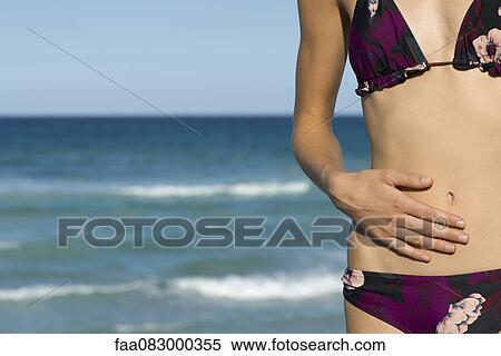 Stock Photography - Woman in bikini, mid section. Fotosearch