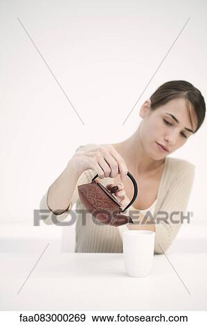 Stock Photo - Woman pouring cup of tea. Fotosearch