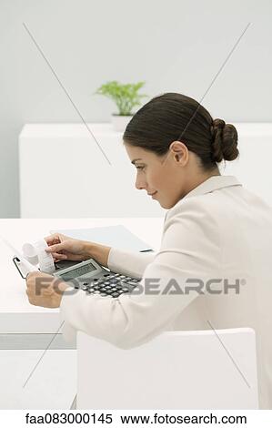 Woman reviewing adding machine printout in office View Large Photo Image Stock Photography - Woman reviewing adding machine printout in office. Fotosearch