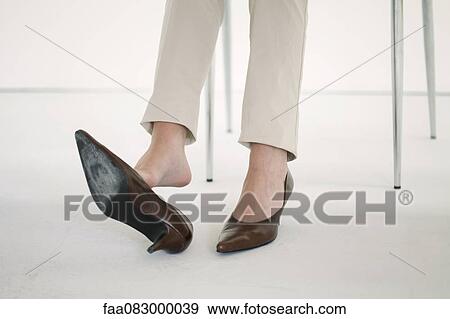 Woman taking off high heel shoe, cropped View Large Photo Image Stock Photo - Woman taking off high heel shoe, cropped. Fotosearch