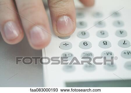 Stock Image - Woman using calculator, extreme close-up. Fotosearch