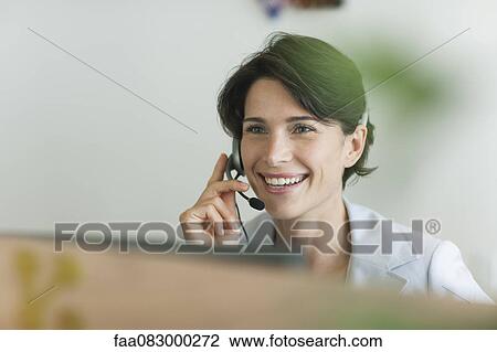 Woman using headset, smiling cheerfully View Large Photo Image Stock Image - Woman using headset, smiling cheerfully. Fotosearch