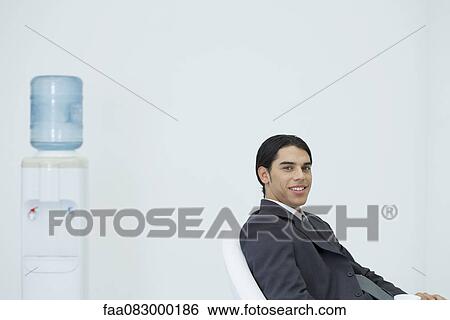 Young businessman taking a coffee break View Large Photo Image Stock Photograph - Young businessman taking a coffee break. Fotosearch