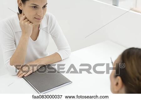 Stock Photo - Young businesswoman conducting job interview. Fotosearch