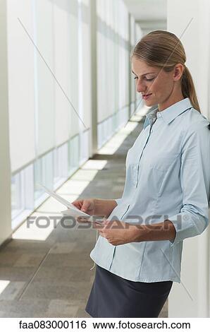 Stock Photograph - Young businesswoman reading document. Fotosearch