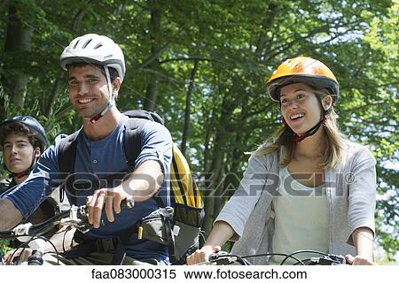 Stock Photography - Young cyclists riding in woods. Fotosearch