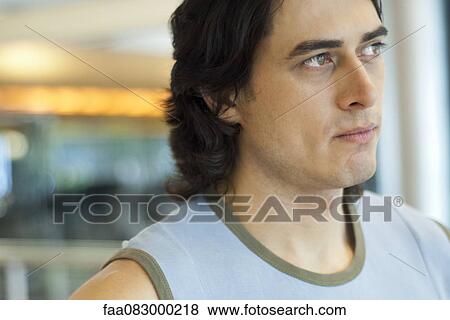 Stock Photo - Young man looking away in thought. Fotosearch