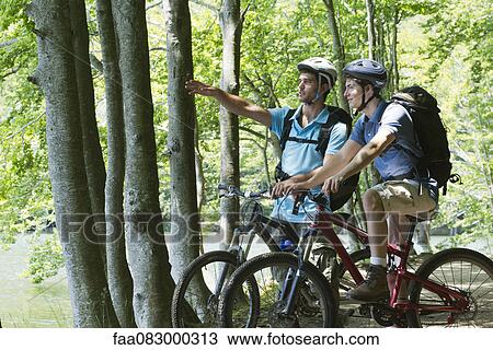 Young men riding bicyckles in woods View Large Photo Image Stock Image - Young men riding bicyckles in woods. Fotosearch