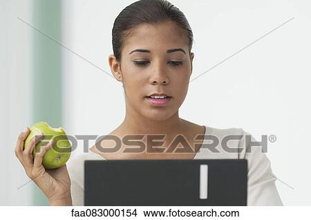 Young woman eating apple View Large Photo Image Picture - Young woman eating apple. Fotosearch