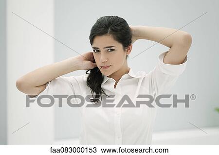 Young woman fixing hair, holding hairpin in mouth View Large Photo Image Stock Image - Young woman fixing hair, holding hairpin in mouth. Fotosearch