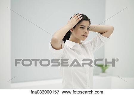 Young woman fixing hair, holding hairpin in mouth View Large Photo Image Stock Photo - Young woman fixing hair, holding hairpin in mouth. Fotosearch