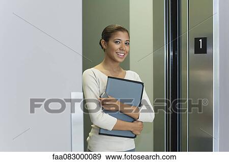 Young woman getting out of elevator View Large Photo Image Stock Photo - Young woman getting out of elevator. Fotosearch