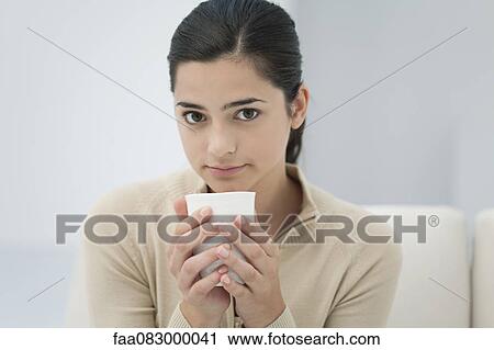 Young woman holding drink, portrait View Large Photo Image Stock Image - Young woman holding drink, portrait. Fotosearch