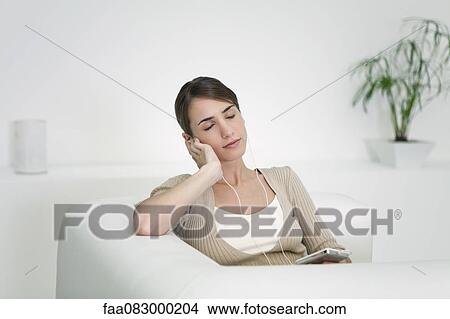 Young woman listening to MP3 player with eyes closed View Large Photo Image Picture - Young woman listening to MP3 player with eyes closed. Fotosearch