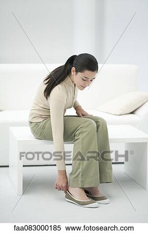 Young woman putting on shoes View Large Photo Image Stock Photography - Young woman putting on shoes. Fotosearch