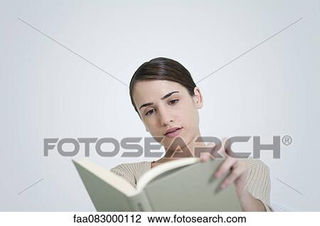 Stock Image - Young woman reading book. Fotosearch