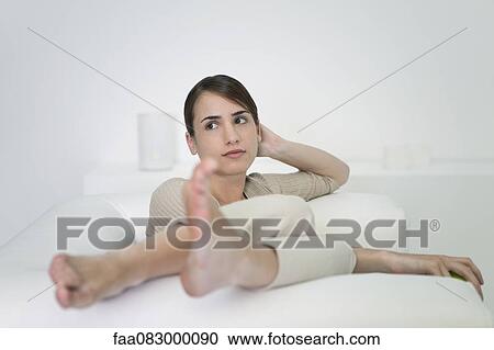 Young woman relaxing on sofa View Large Photo Image Stock Image - Young woman relaxing on sofa. Fotosearch