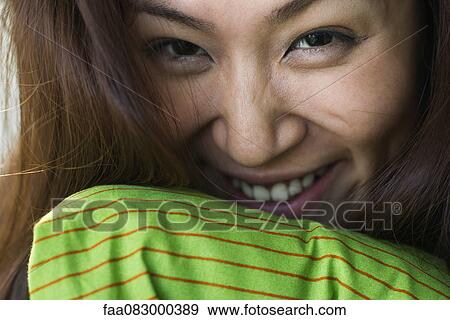 Stock Photo - Young woman smiling cheerfully, portrait. Fotosearch
