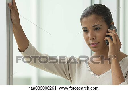 Young woman talking on cell phone View Large Photo Image Stock Image - Young woman talking on cell phone. Fotosearch