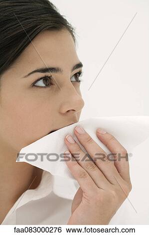 Stock Photograph - Young woman wiping mouth with napkin. Fotosearch