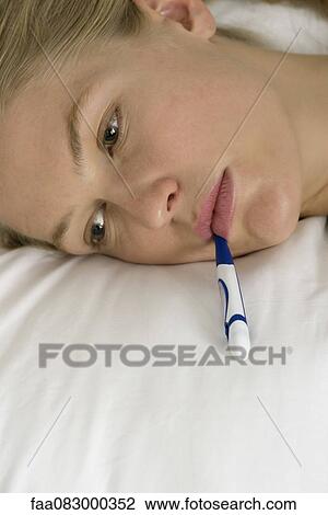 Young woman with thermometer in mouth, cropped View Large Photo Image Stock Image - Young woman with thermometer in mouth, cropped. Fotosearch