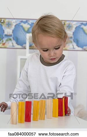 Baby boy carefully lining up blocks View Large Photo Image Stock Photo - Baby boy carefully lining up blocks. Fotosearch