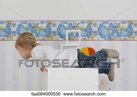 Baby boy climbing on top of furniture View Large Photo Image Stock Image - Baby boy climbing on top of furniture. Fotosearch