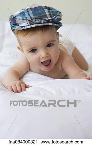 Stock Image - Baby boy wearing cap, portrait. Fotosearch