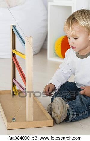 Baby playing with marble rolling game View Large Photo Image Stock Image - Baby playing with marble rolling game. Fotosearch