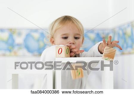 Baby pushing blocks off shelves View Large Photo Image Stock Photograph - Baby pushing blocks off shelves. Fotosearch