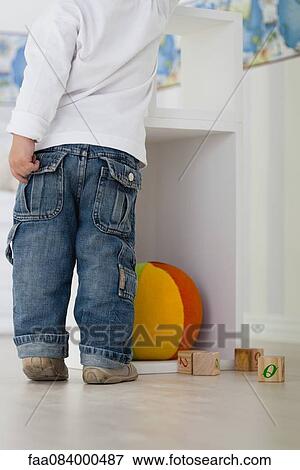 Baby standing in nursery with toys on floor View Large Photo Image Stock Photo - Baby standing in nursery with toys on floor. Fotosearch