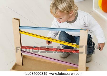 Baby watching marble rolling down bars View Large Photo Image Stock Photo - Baby watching marble rolling down bars. Fotosearch