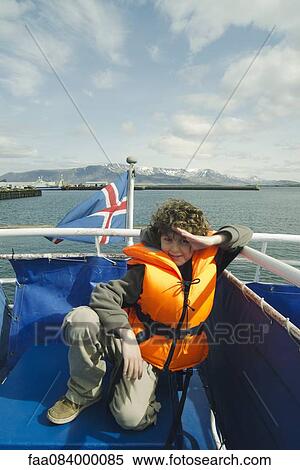 Stock Photography - Boy in a lifejacket on a boat, Reykjavik Iceland. Fotosearch