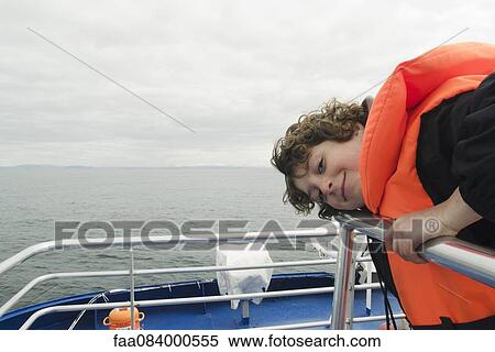 Boy leaning on the deck of a boat, smiling View Large Photo Image Stock Photography - Boy leaning on the deck of a boat, smiling. Fotosearch