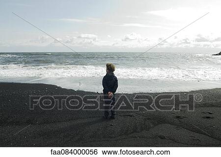 Boy looking horizon facing the sea, iceland View Large Photo Image Stock Photograph - Boy looking horizon facing the sea, iceland. Fotosearch
