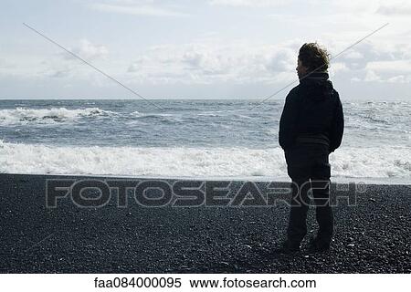 Boy looking horizon facing the sea, iceland View Large Photo Image Stock Photography - Boy looking horizon facing the sea, iceland. Fotosearch