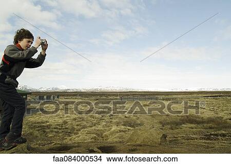 Boy photographing the Gullfoss landscape, Iceland View Large Photo Image Picture - Boy photographing the Gullfoss landscape, Iceland. Fotosearch