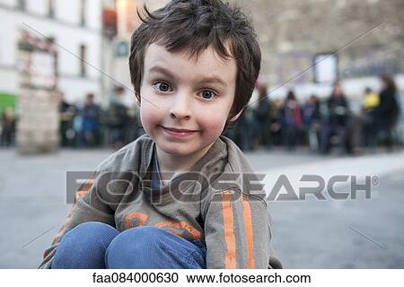 Boy sitting outdoors in urban setting, portrait View Large Photo Image Stock Image - Boy sitting outdoors in urban setting, portrait. Fotosearch