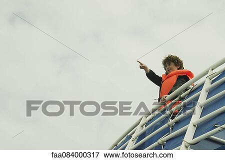 Boy watching the horizon, on the upper deck of a boat View Large Photo Image Stock Photo - Boy watching the horizon, on the upper deck of a boat. Fotosearch