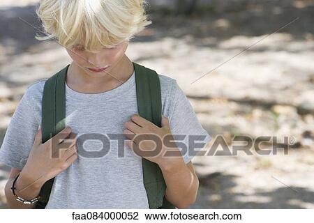 Boy wearing backpack, head down, portrait View Large Photo Image Stock Image - Boy wearing backpack, head down, portrait. Fotosearch
