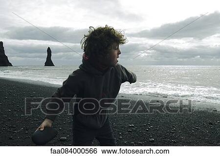 Boy who ricochets on the beach Iceland View Large Photo Image Stock Photograph - Boy who ricochets on the beach Iceland. Fotosearch