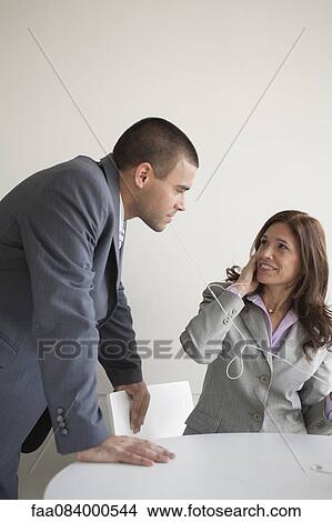 Business colleagues sharing earphones View Large Photo Image Picture - Business colleagues sharing earphones. Fotosearch