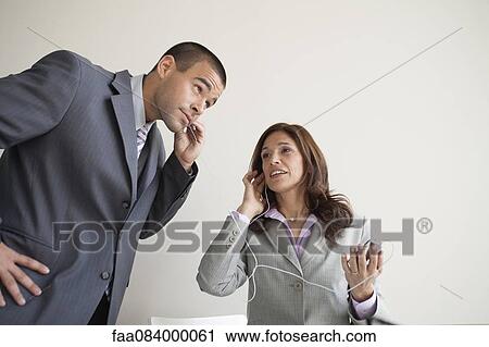 Business colleagues sharing earphones View Large Photo Image Stock Image - Business colleagues sharing earphones. Fotosearch