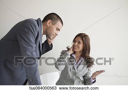 Business colleagues sharing earphones View Large Photo Image Stock Image - Business colleagues sharing earphones. Fotosearch