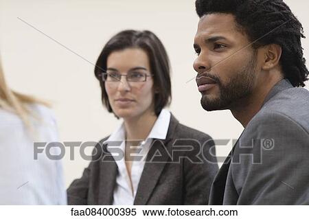 Business people in meeting, focus on one young man View Large Photo Image Stock Photography - Business people in meeting, focus on one young man. Fotosearch